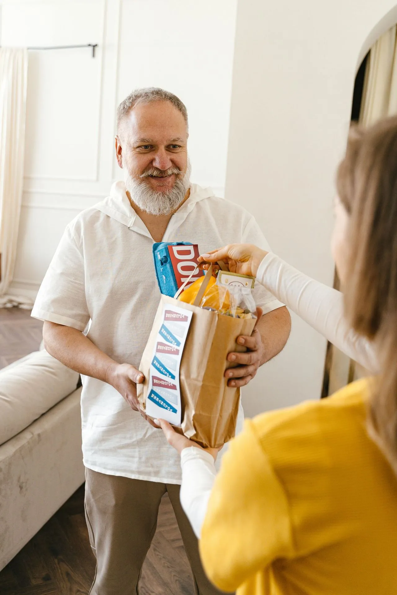 Caregiver delivering fresh groceries to a senior client at home